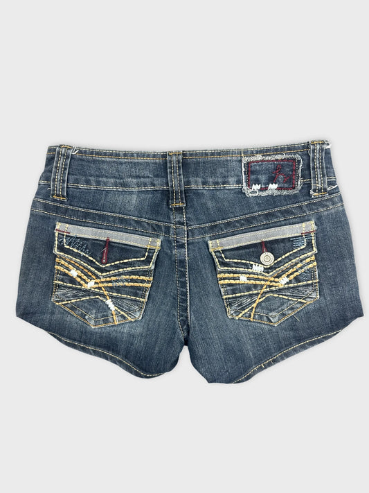 Back view of women denim shorts featuring decorative pocket details and dark blue color.