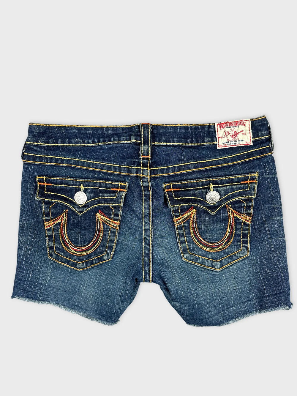 Back view of denim shorts featuring yellow and red stitching details.