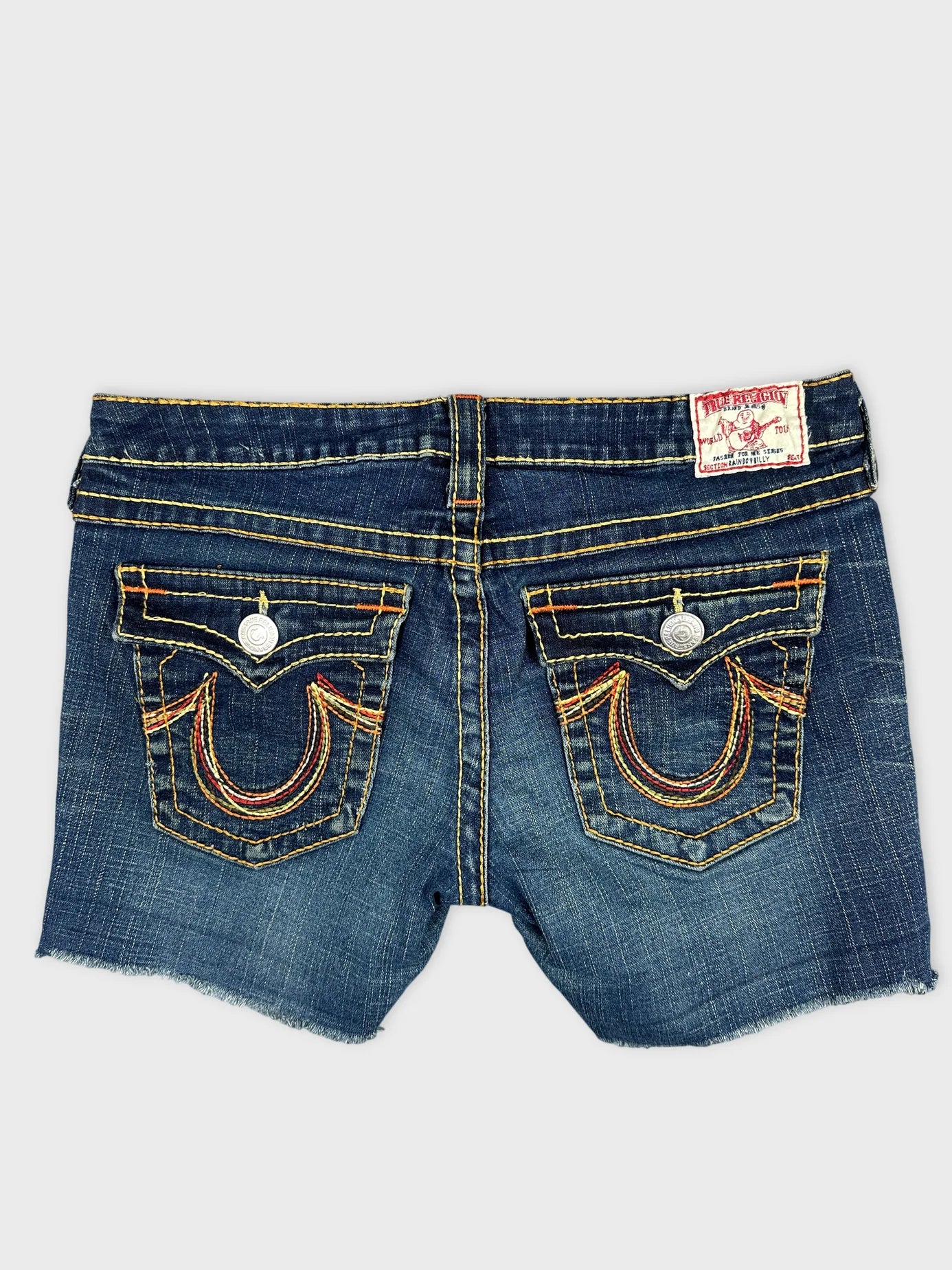 Back view of denim shorts featuring yellow and red stitching details.