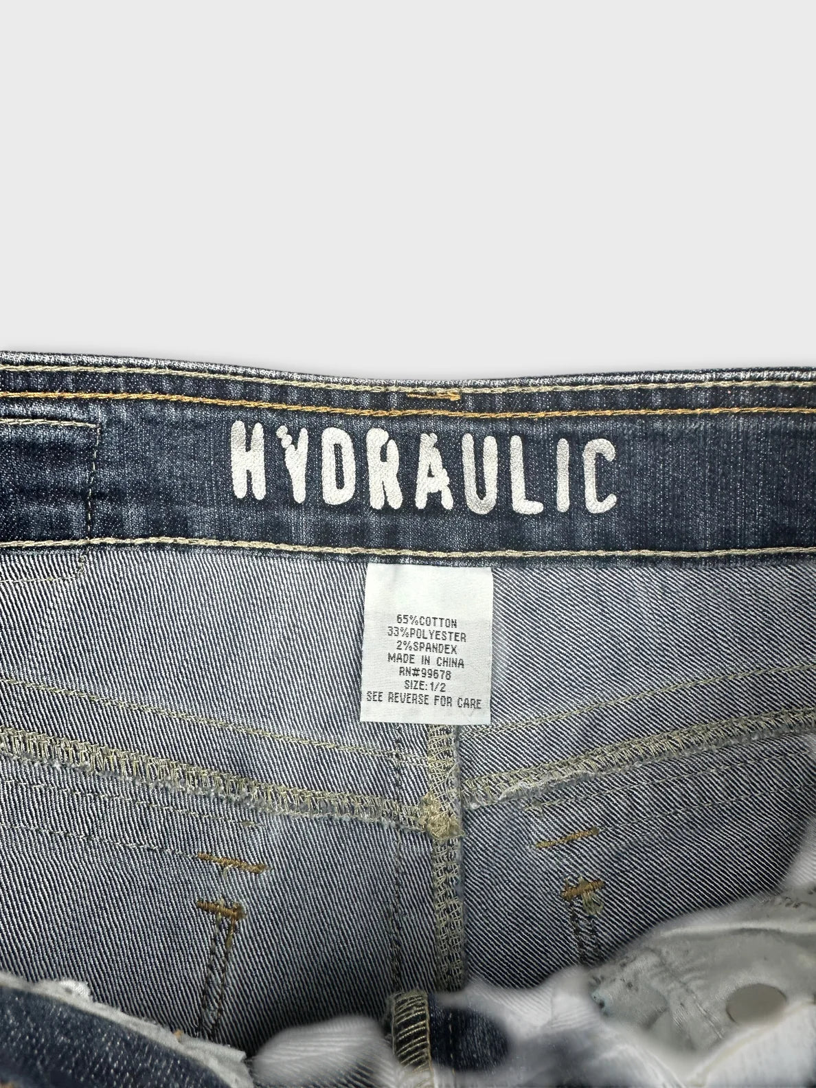 Detail view of women's denim shorts in dark blue with brand label.