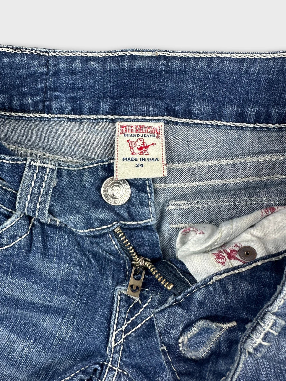 Detail view of women's denim shorts in blue with zipper closure.