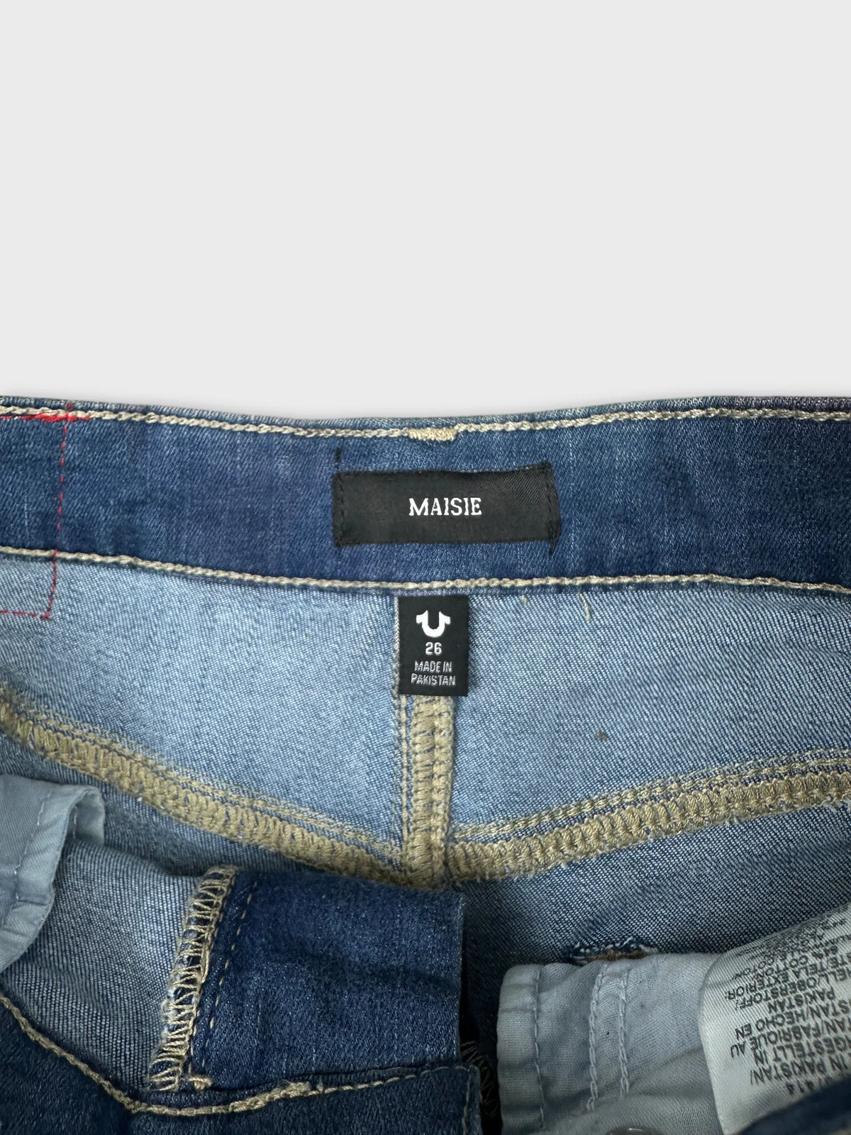 Detail view of women's denim shorts with a blue color and contrasting stitching.