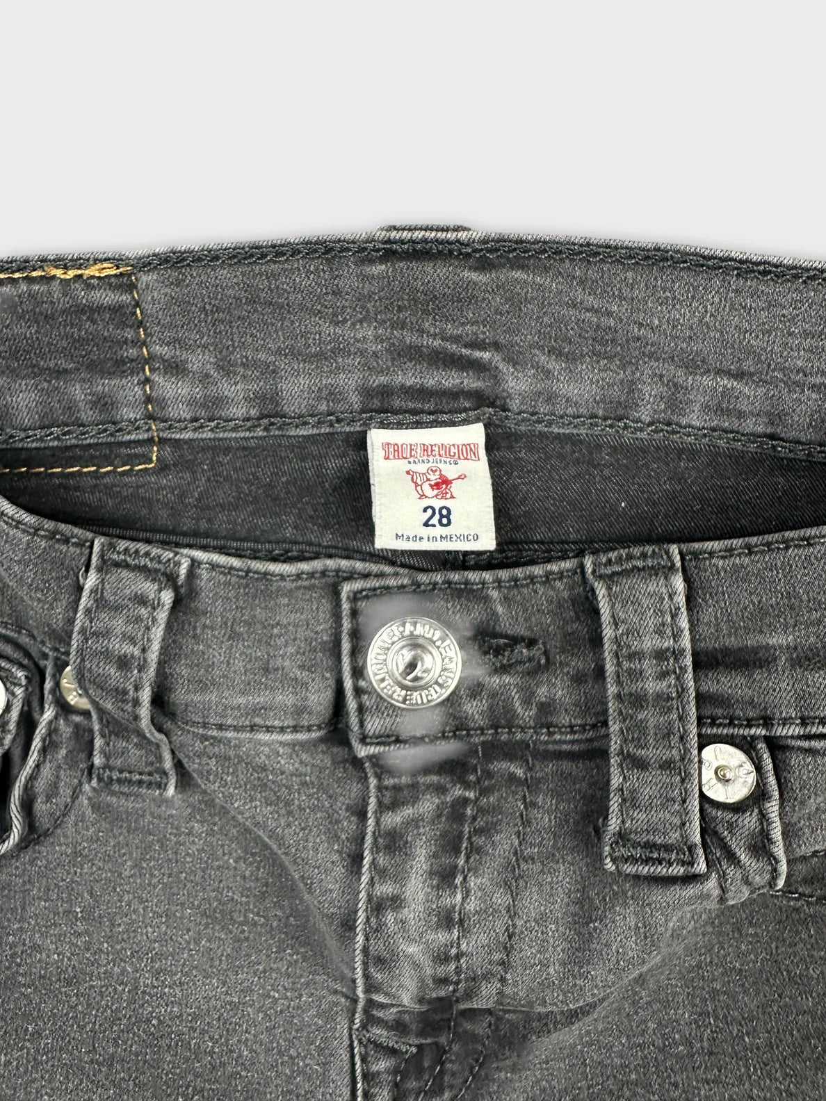 Black denim shorts with silver button detail view.