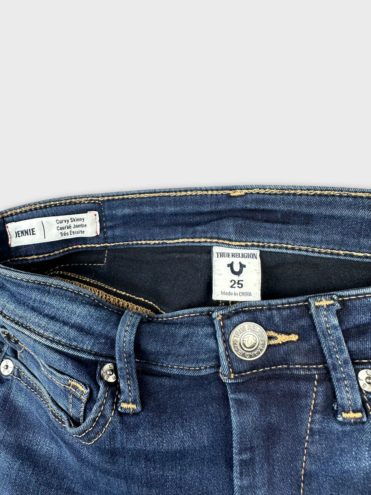 Detail view of women denim shorts featuring dark blue color and front button closure.