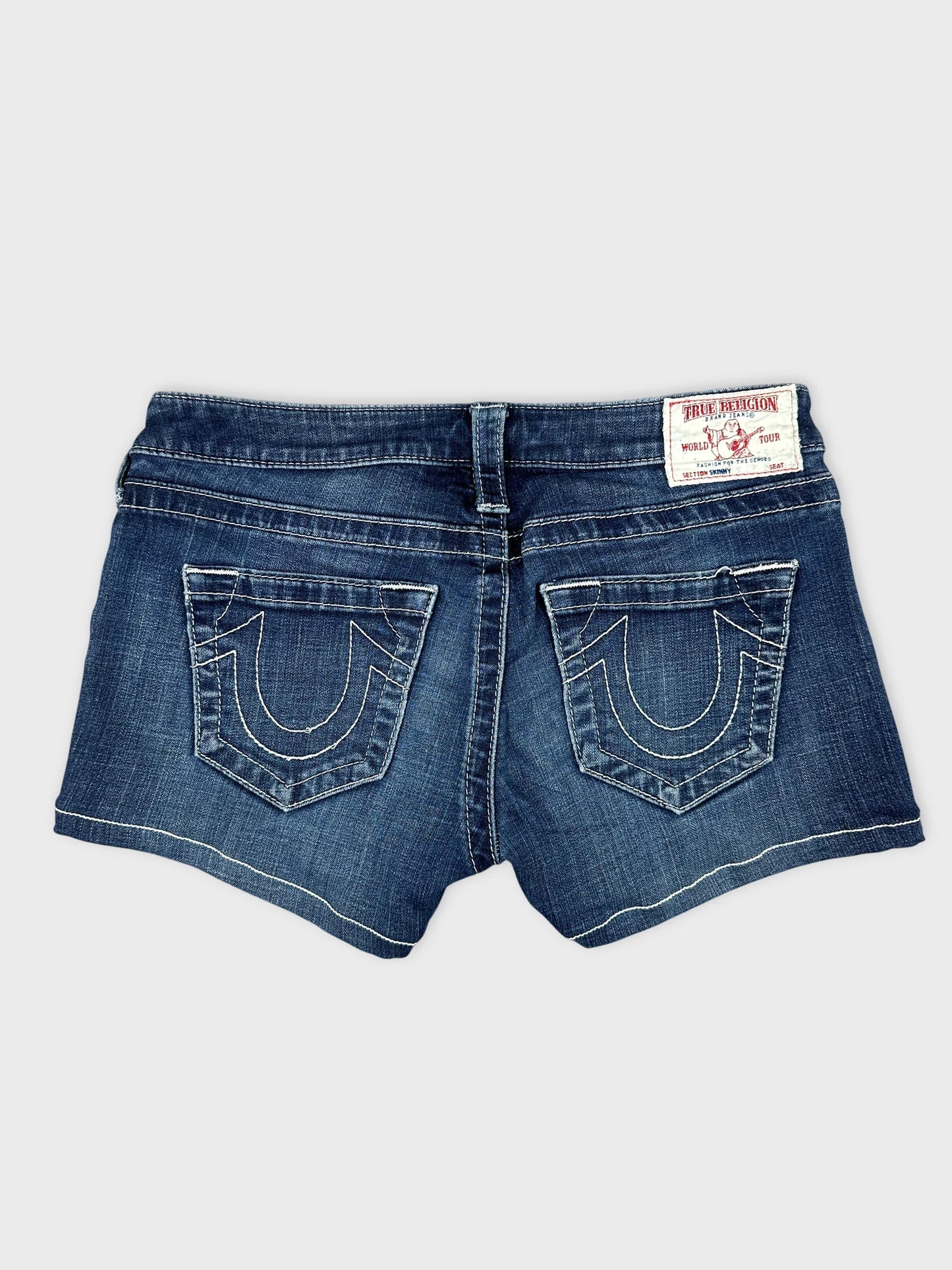 Detail view of women denim shorts in dark blue with decorative back pockets.