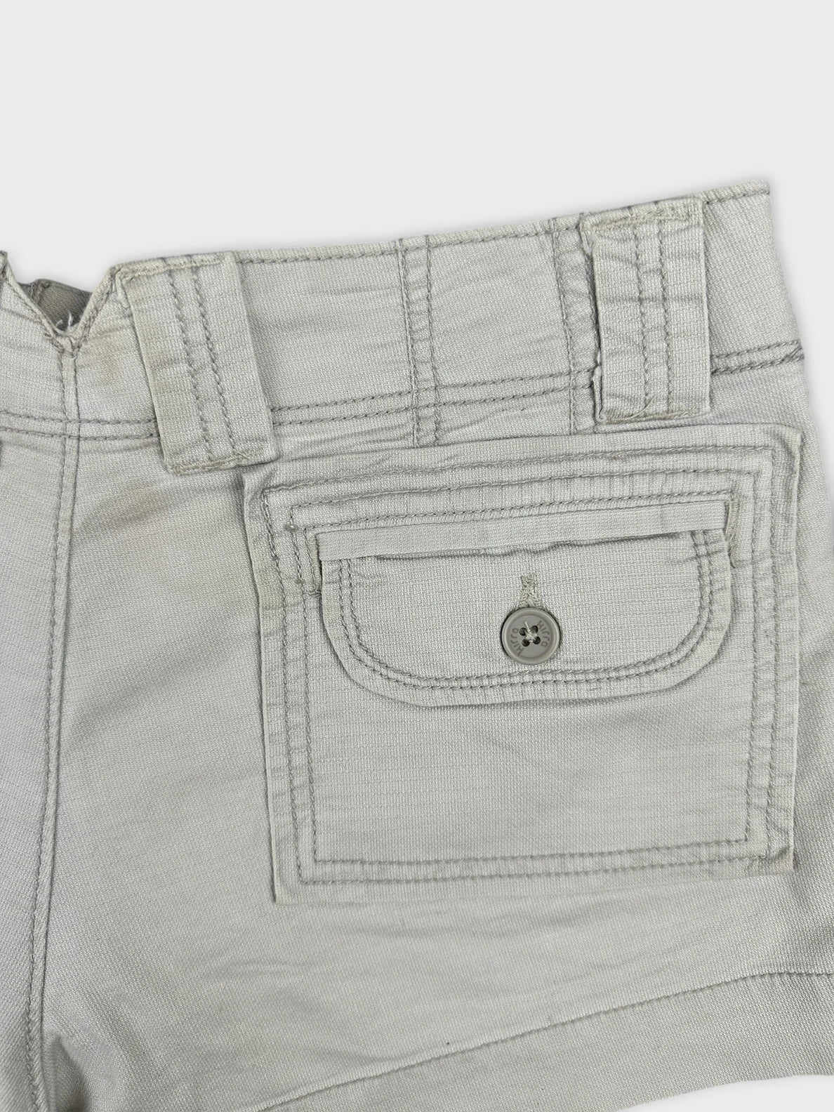 Detail view of women's denim shorts in light gray with back pocket.