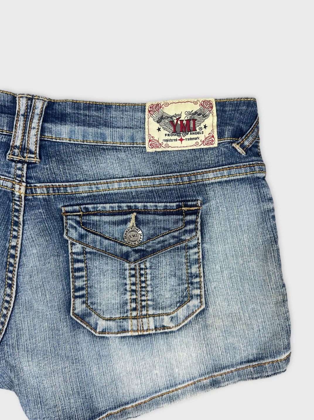 Detail view of women denim shorts featuring faded blue color and pocket design.