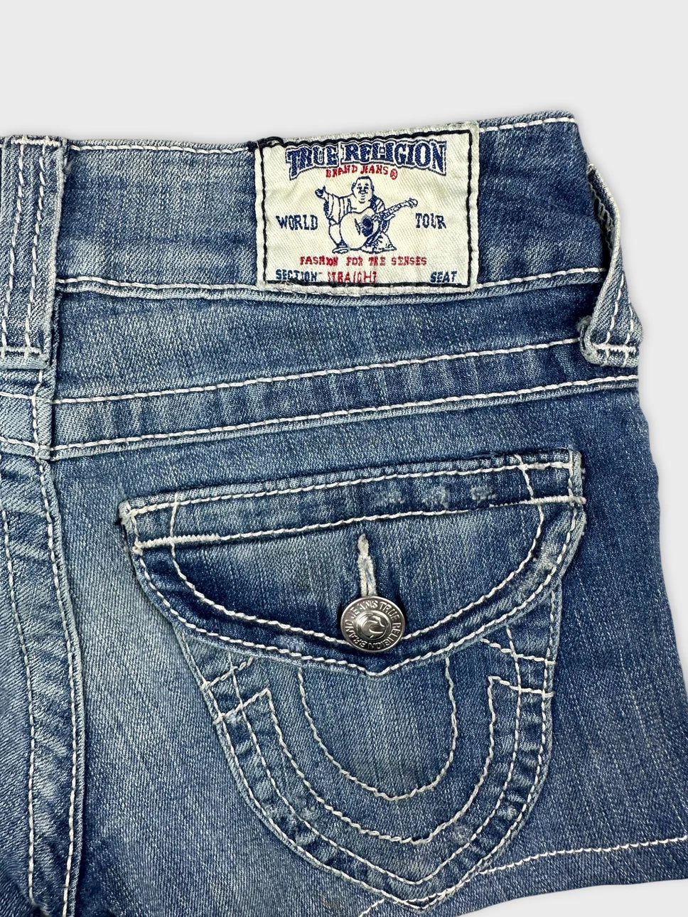 Detail view of denim shorts in blue with distinctive back pocket stitching.