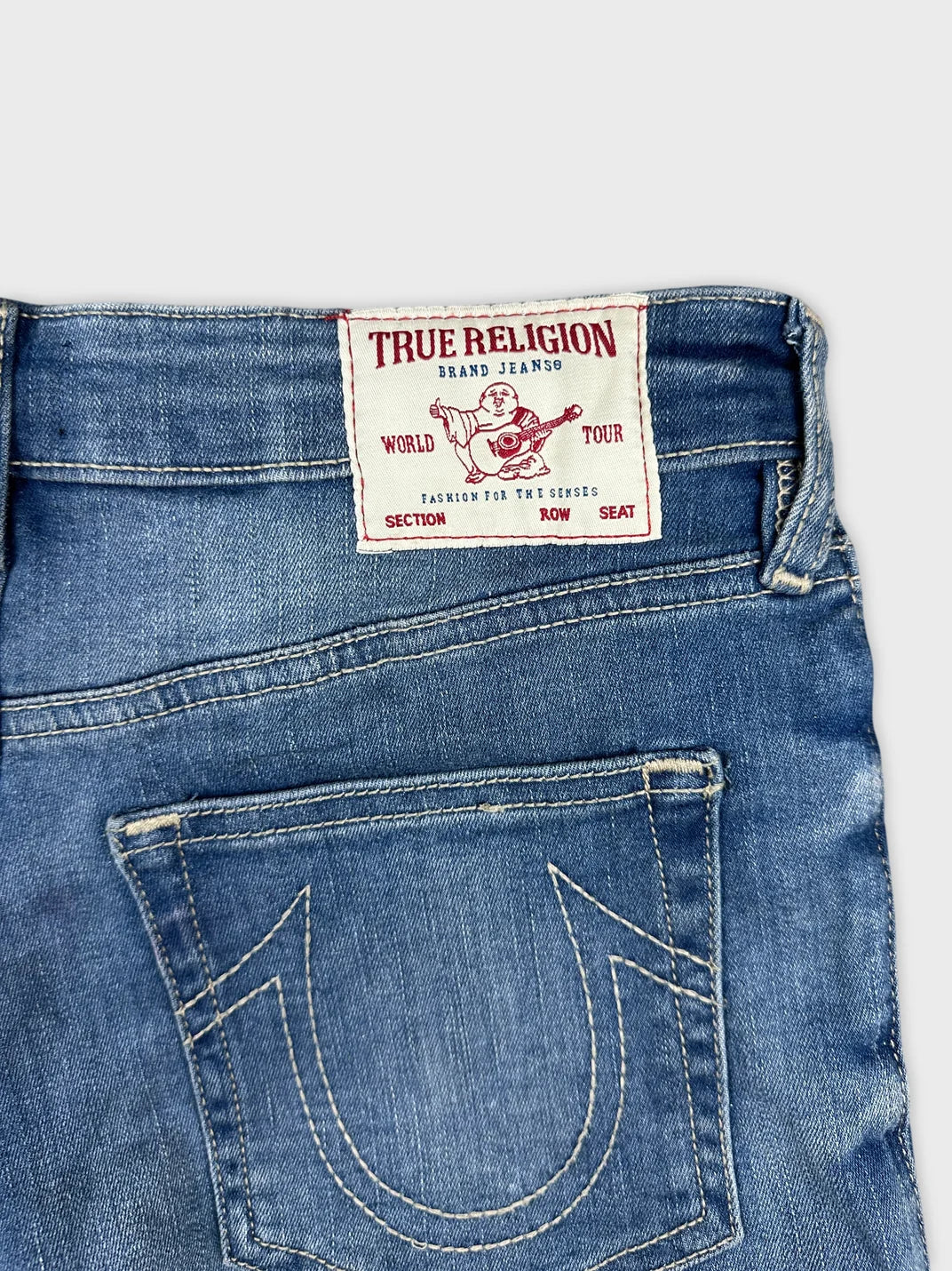 Detail view of women denim shorts in light blue with True Religion branding