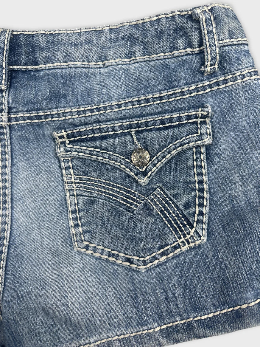 Detail view of women's denim shorts in blue with distinctive pocket stitching.