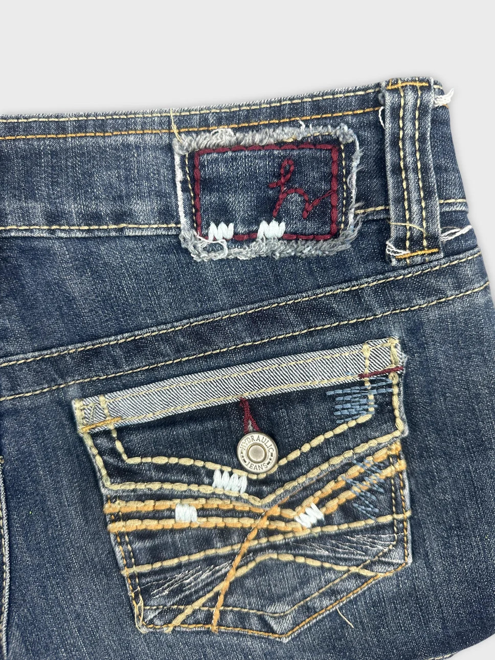 Detail view of women denim shorts featuring embroidery on the back pocket.