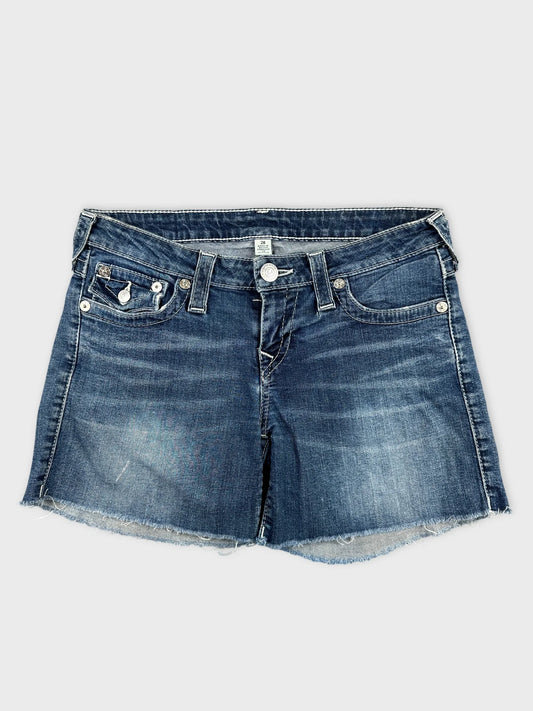 Front view of women denim shorts in dark blue with frayed hem.