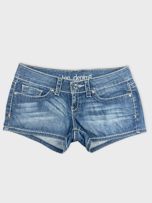 Front view of denim shorts featuring a faded blue color and white stitching.