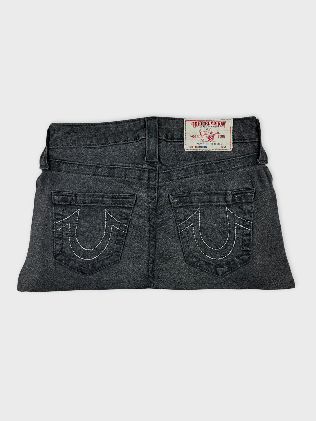 Back view of a women’s denim skirt in dark gray with decorative pockets.
