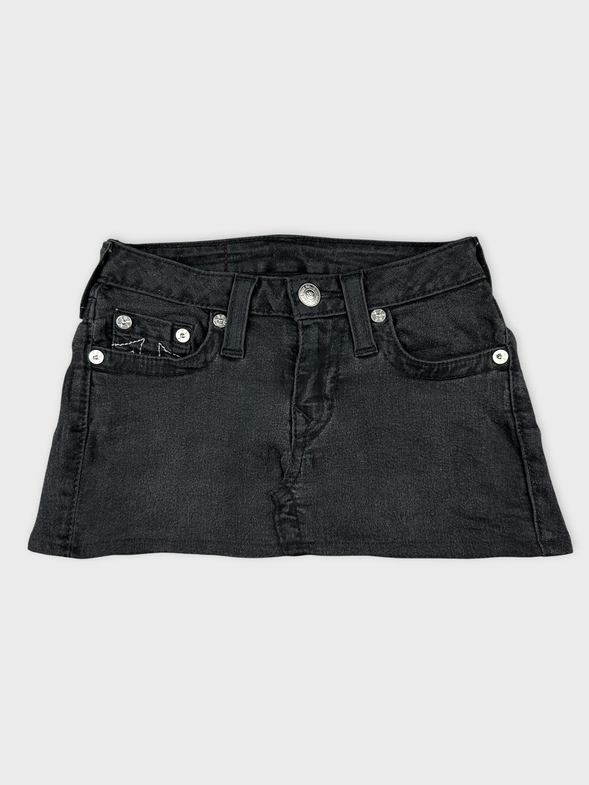Front view of a black denim skirt with front pockets and button details.
