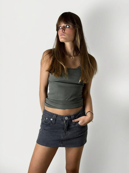 Front view of a women denim skirt in dark wash with front pockets.