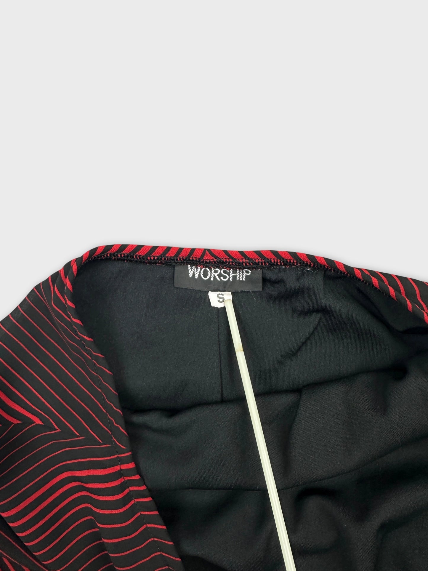 Detail view of a women long dress in black with red striped pattern.