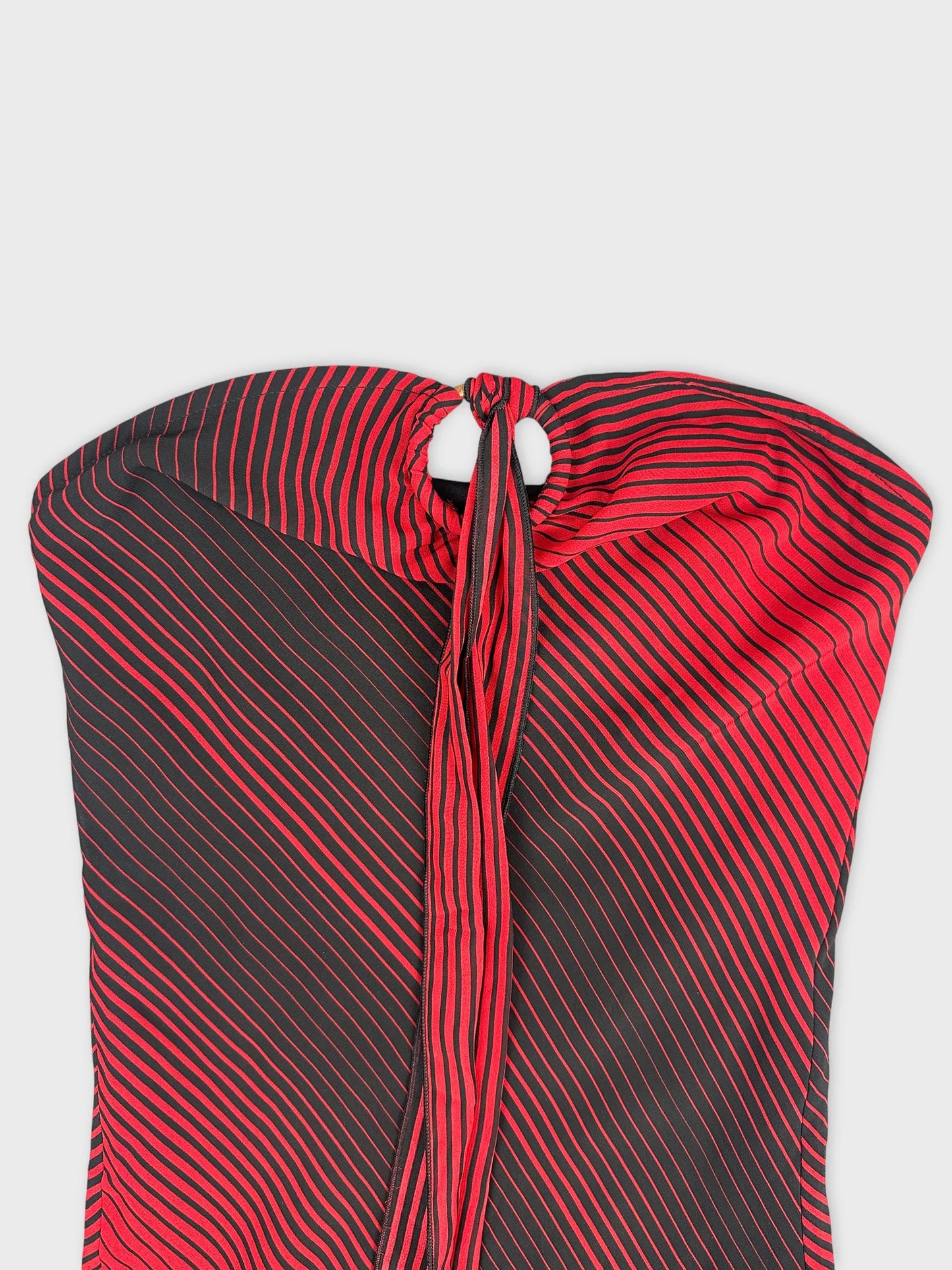Detail view of a long dress featuring red and black striped pattern.
