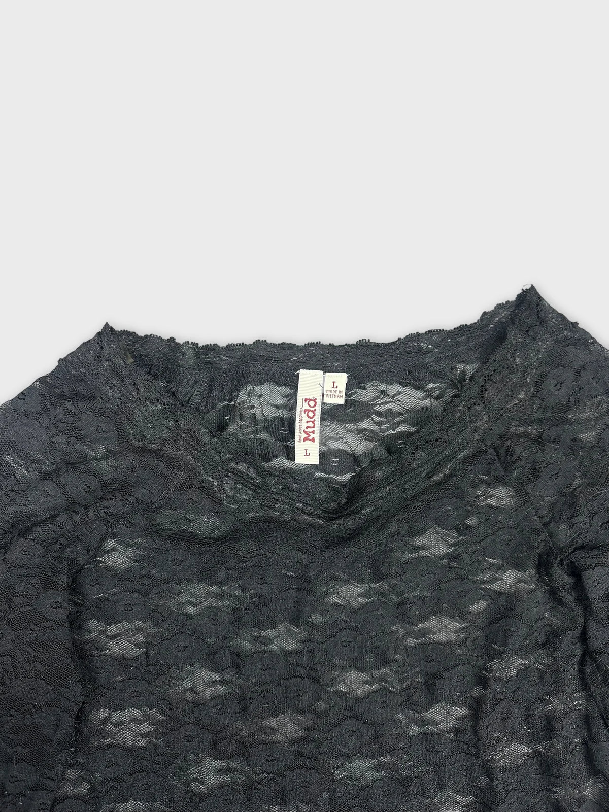 Detail view of a black long sleeve lace blouse with sheer texture.
