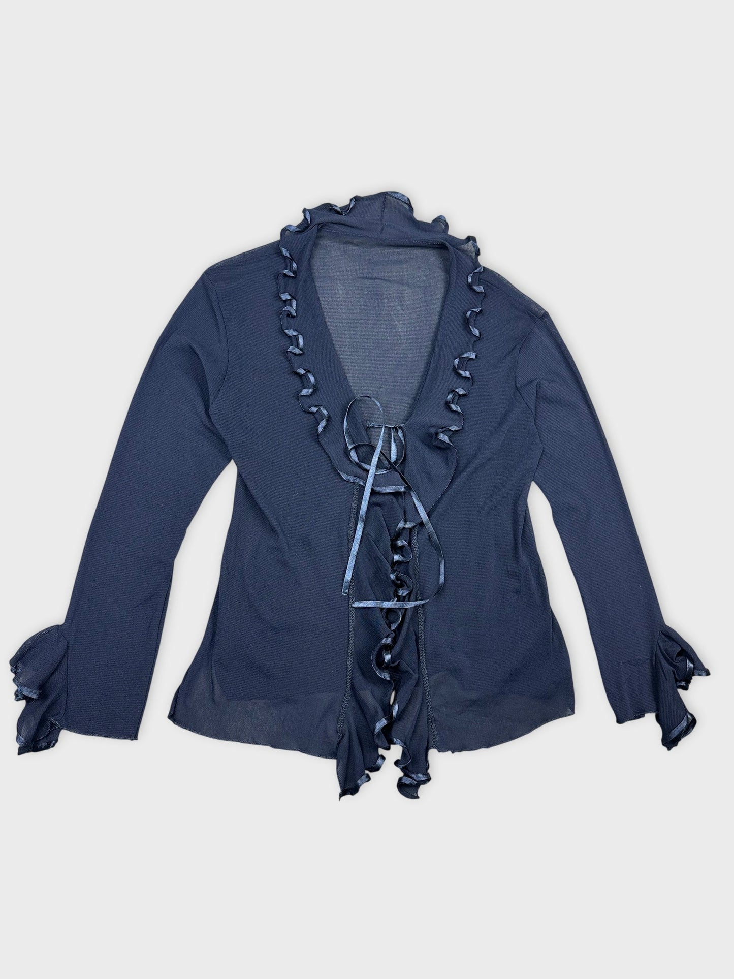 Detail view of a long sleeve shirt in navy with ruffled trim.