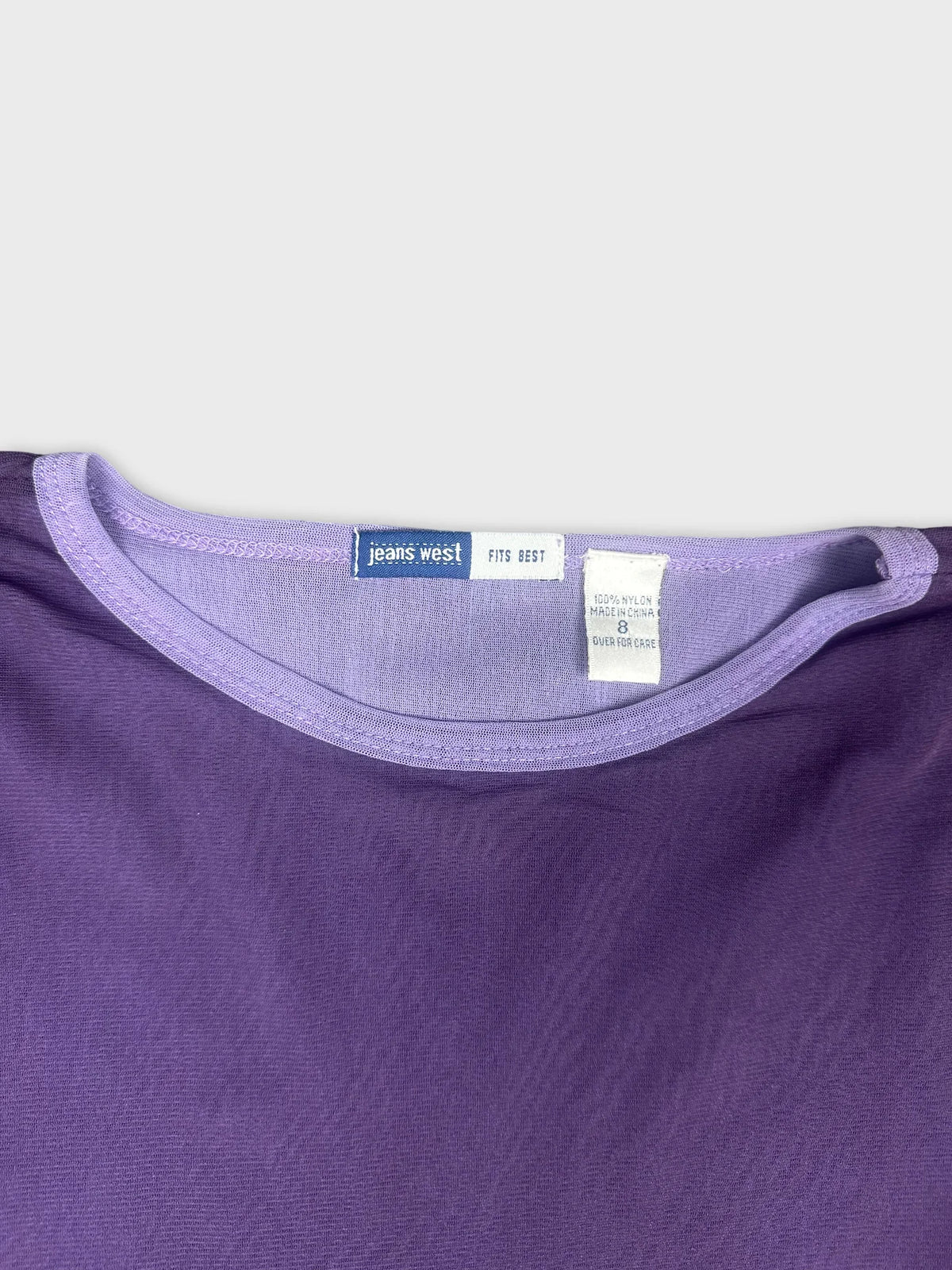 Detail view of long sleeve shirt in purple with a soft round neckline.