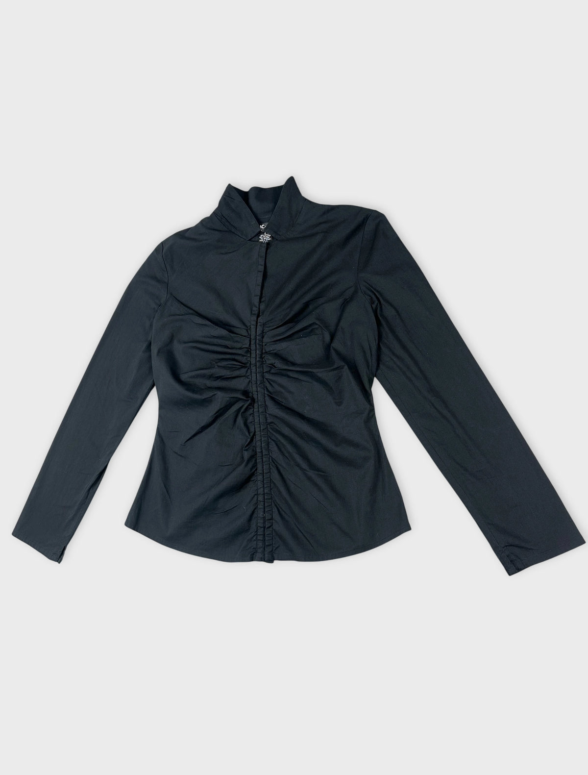 Detail view of black long sleeve shirt featuring gathered fabric at the front.