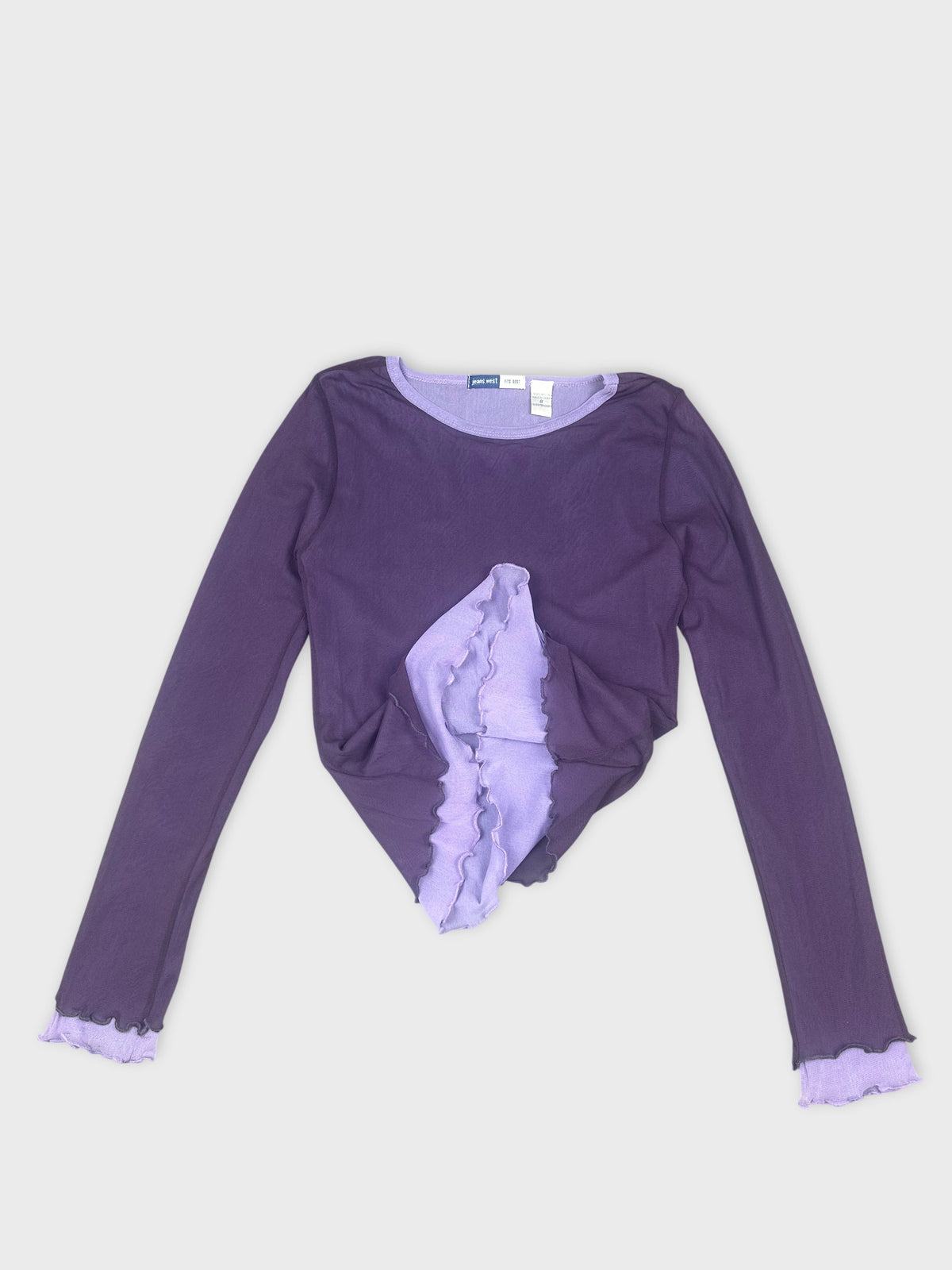 Detail view of a purple long sleeve shirt with ruffled trim