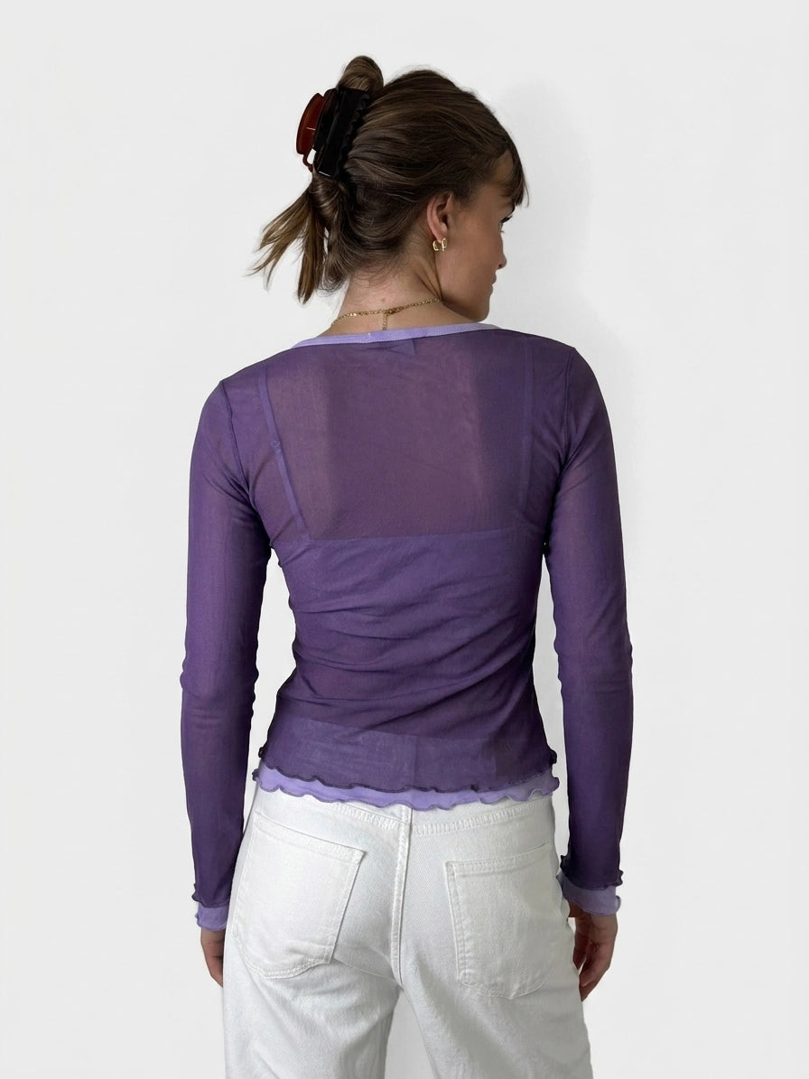 Back view of a long sleeve purple shirt with scalloped trim.