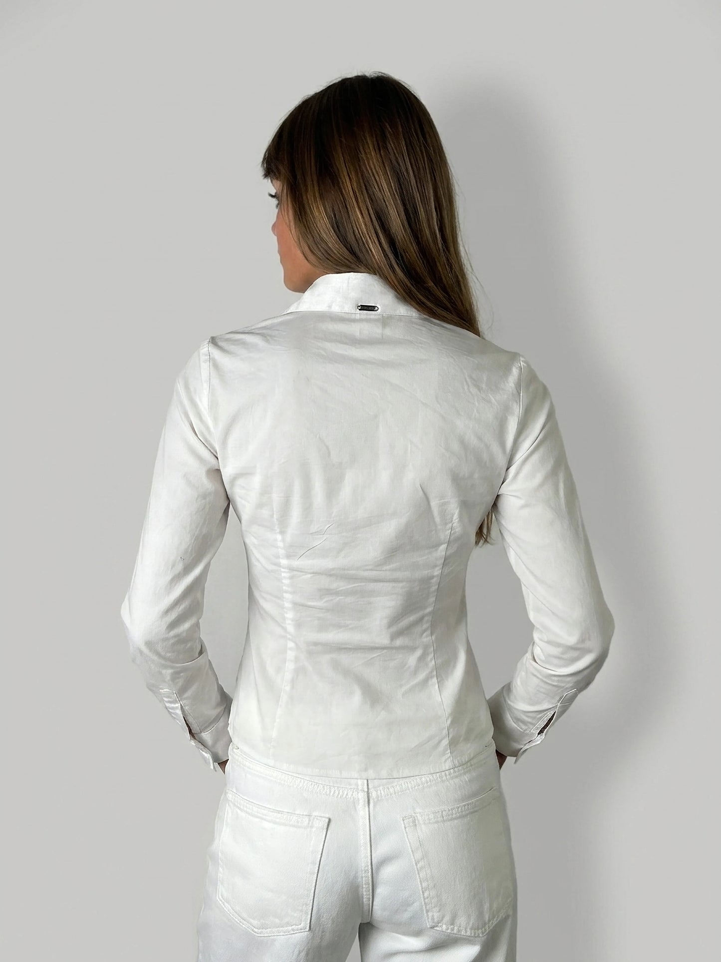 Back view of a white long sleeve shirt featuring a small collar detail.