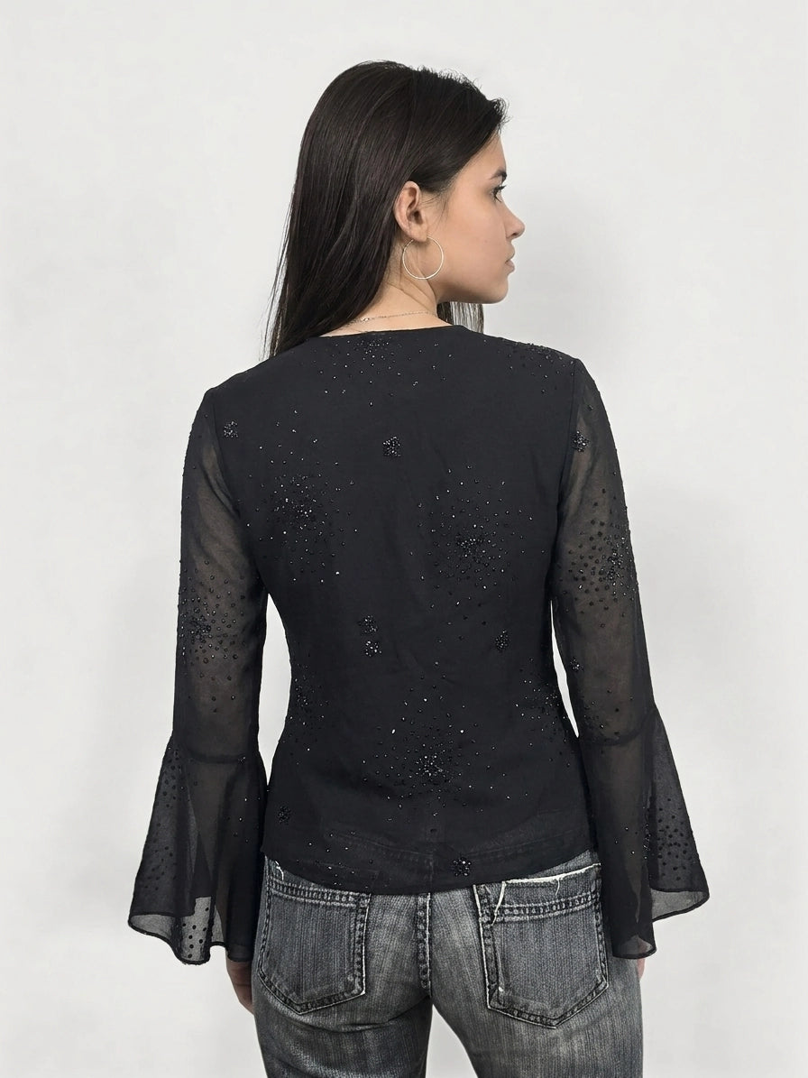 Back view of a black long sleeve shirt with bell sleeves and sequin details.