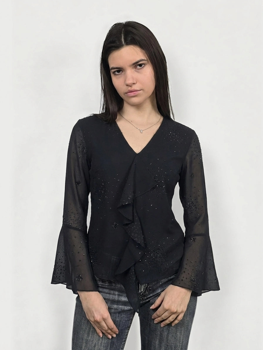 Black long sleeve shirt with ruffled trim, shown in front view.