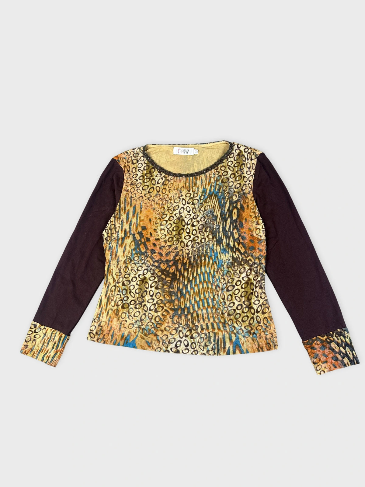 Detail view of a long sleeve top with a colorful abstract print.