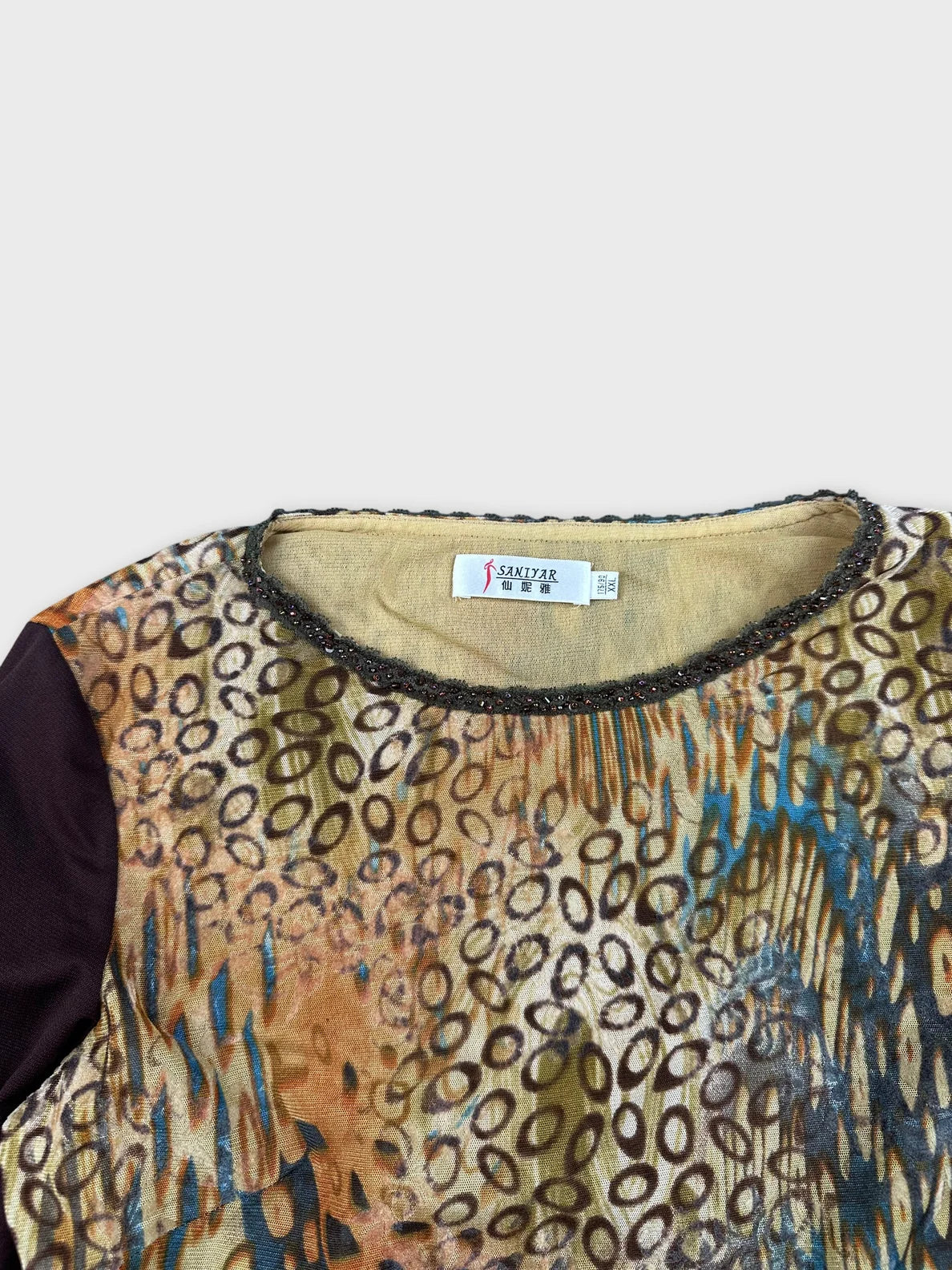 Detail view of a long sleeve top with a colorful abstract pattern