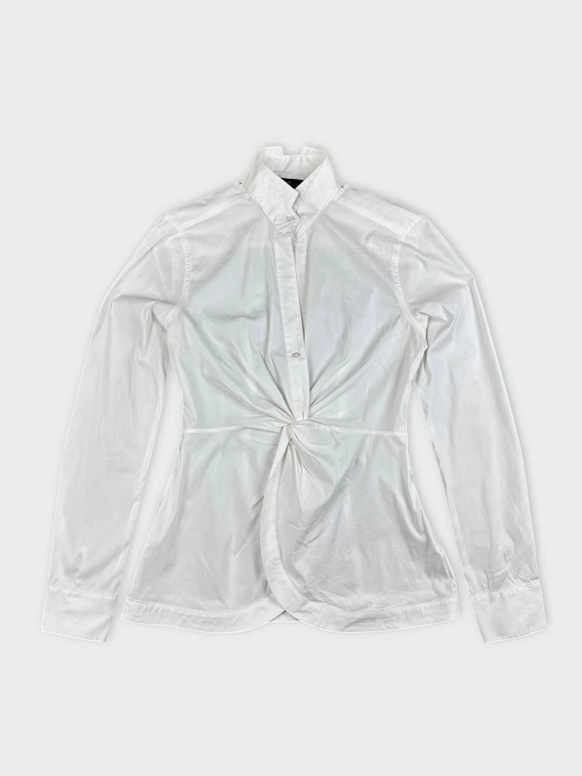 Detail view of a white long sleeve top with a knotted front.