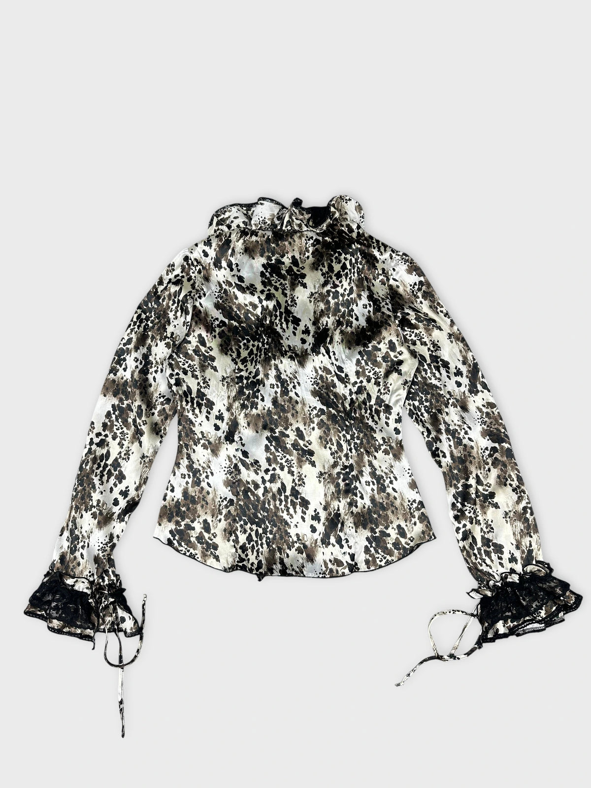 Back view of a long sleeve top in cream with leopard print and lace trim.