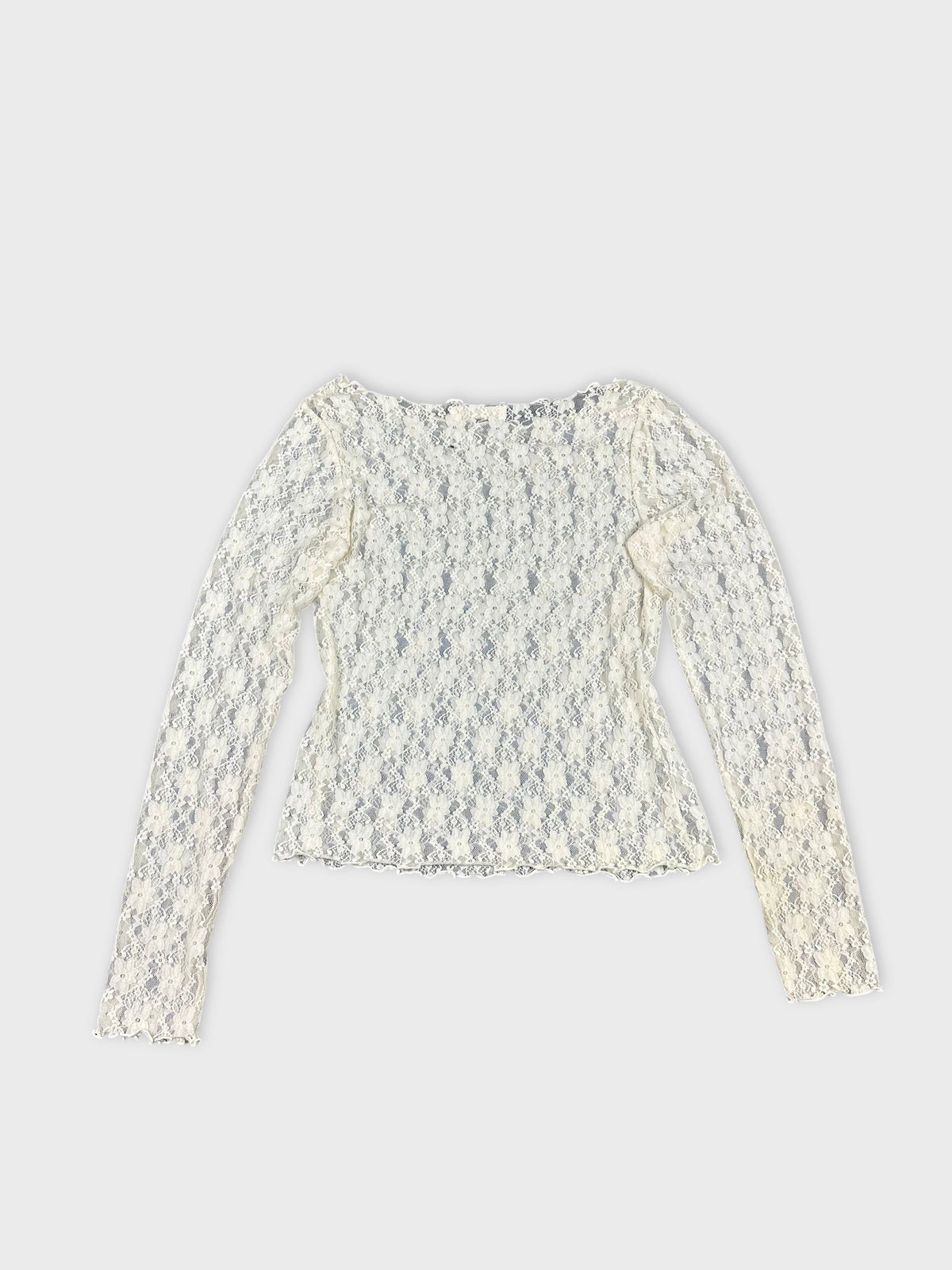 Back view of a cream long sleeve lace top with delicate floral pattern.