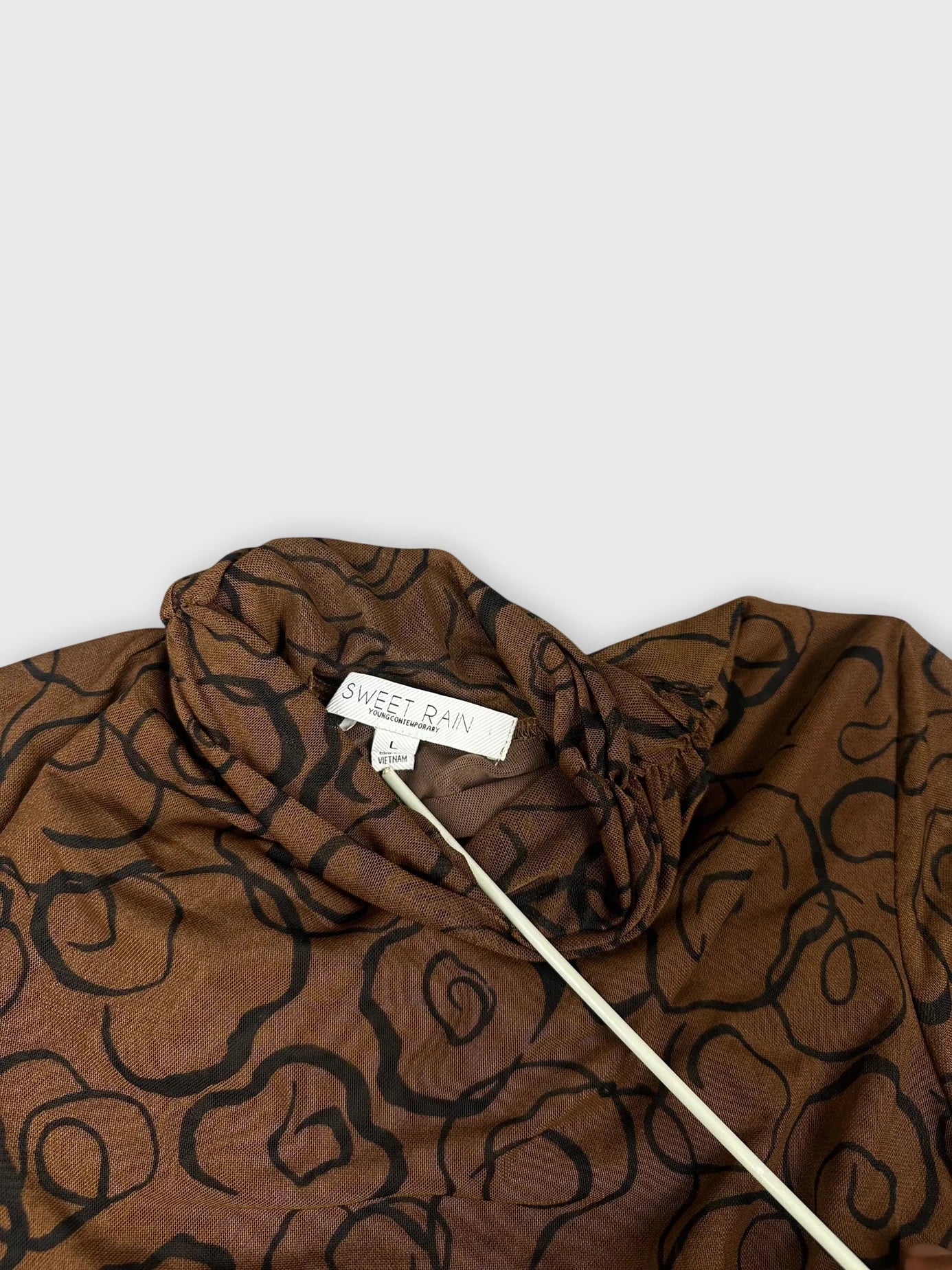 Back view of a brown long sleeve top with a floral print.