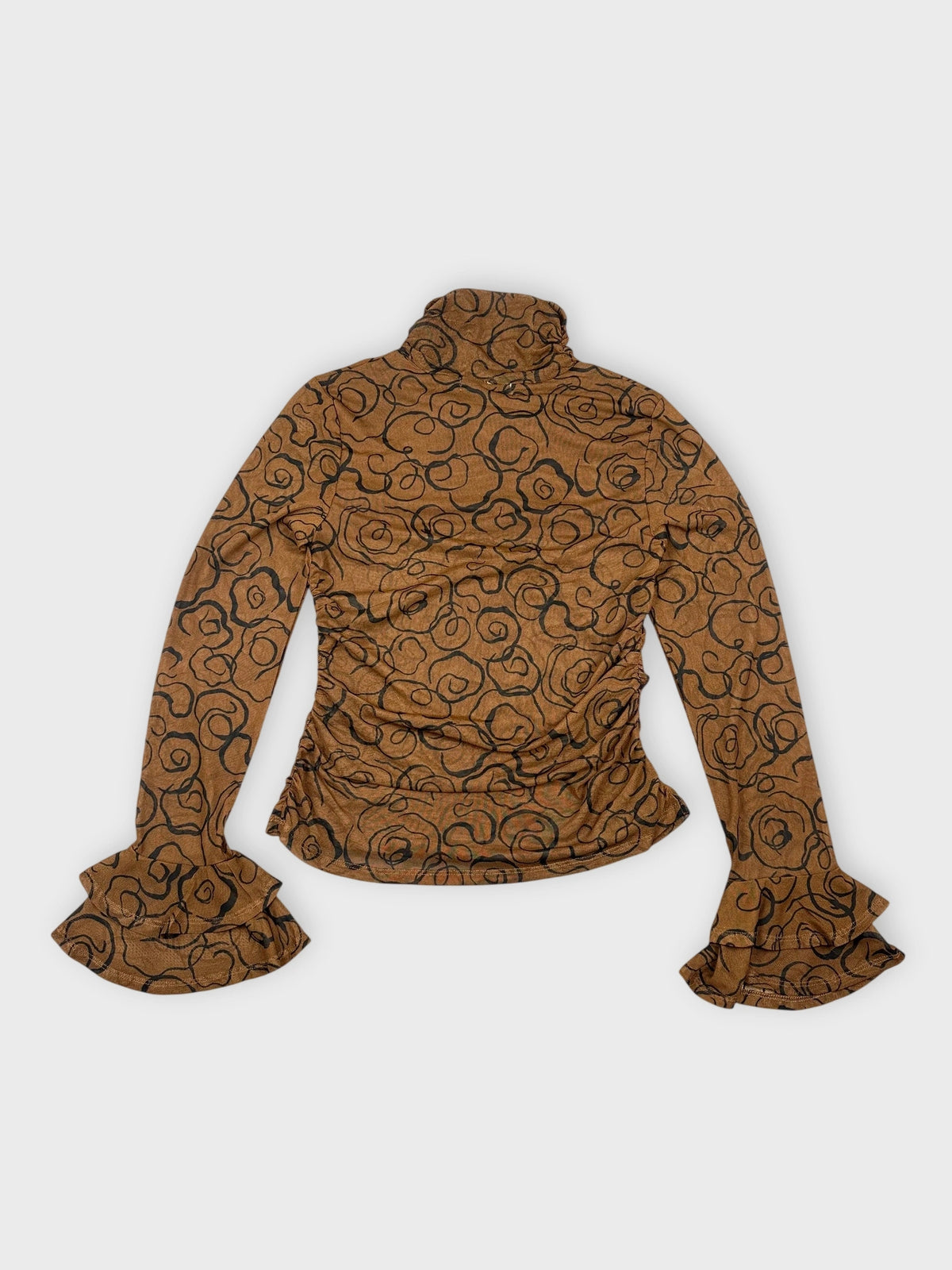 Detail view of a long sleeve top in brown with black rose print.