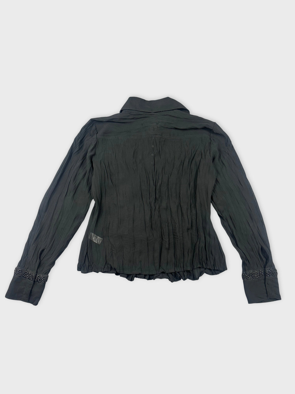 detail view of a long sleeve black top with gathered texture and embellished cuffs