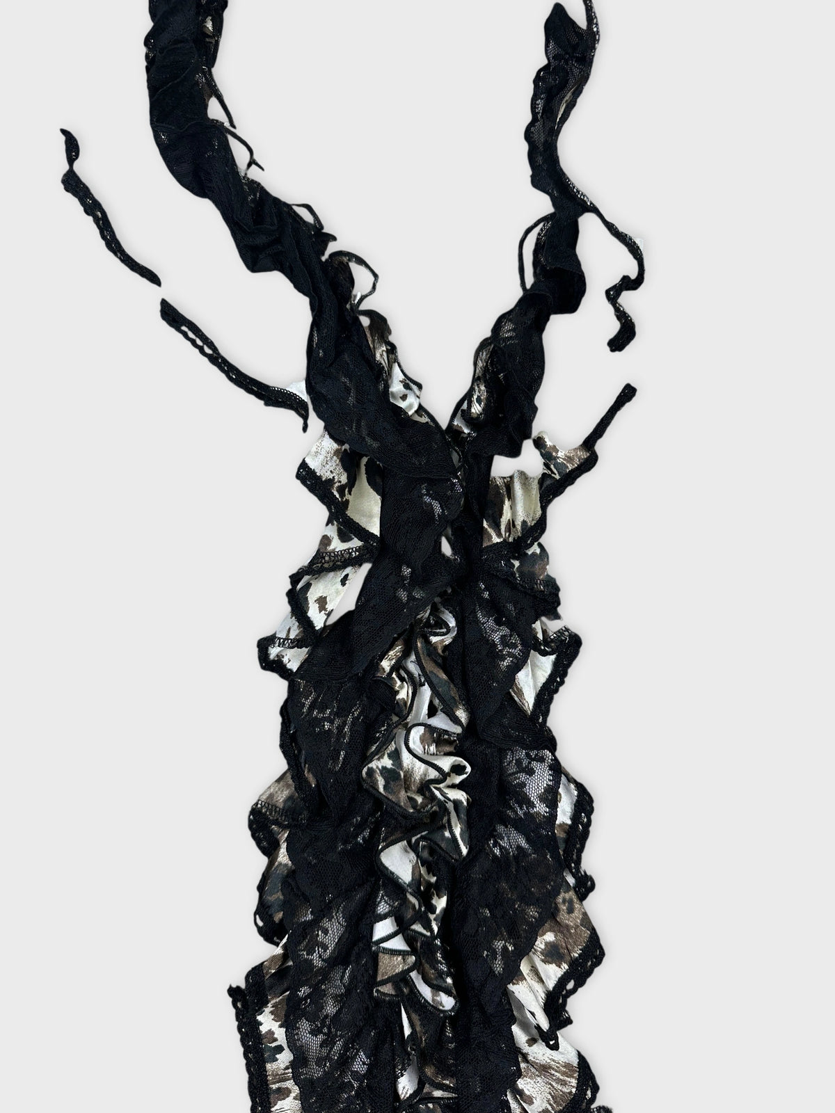 Detail view of a long sleeve top in black with ruffled lace trim.