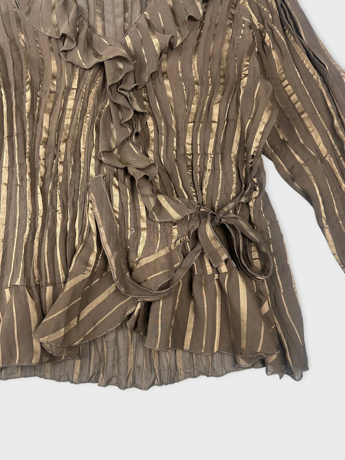 Detail view of a brown long sleeve top with ruffled trim and vertical stripes.