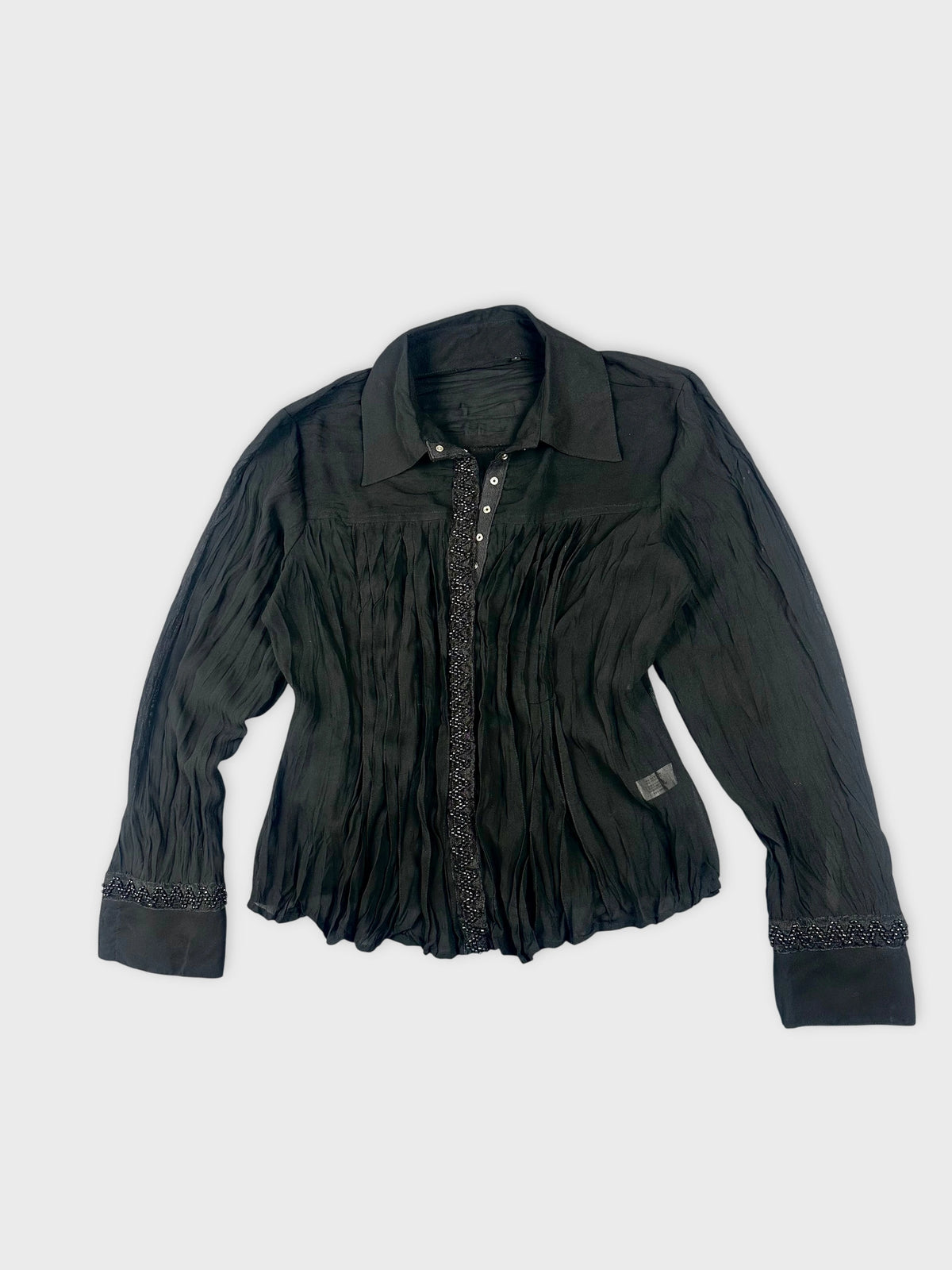 Black long sleeve top with pleated texture and beaded trim detail view