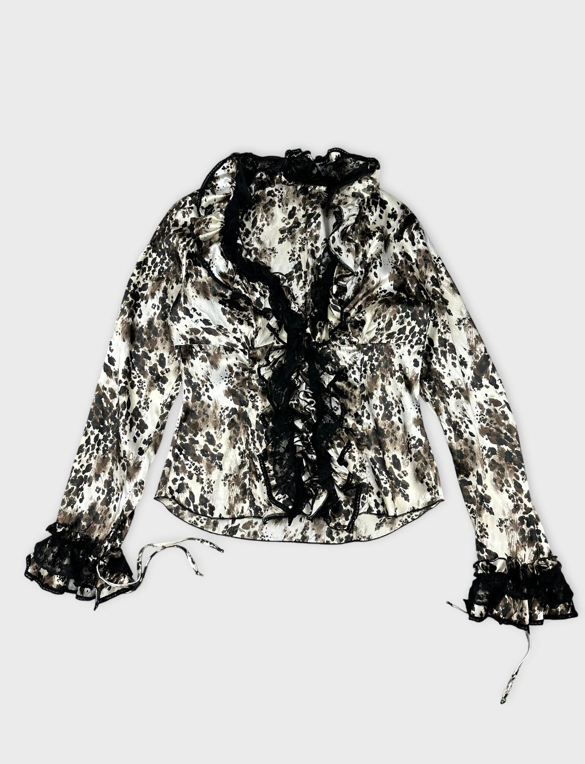 Front view of a vintage long sleeve top in white and brown animal print with lace trim.