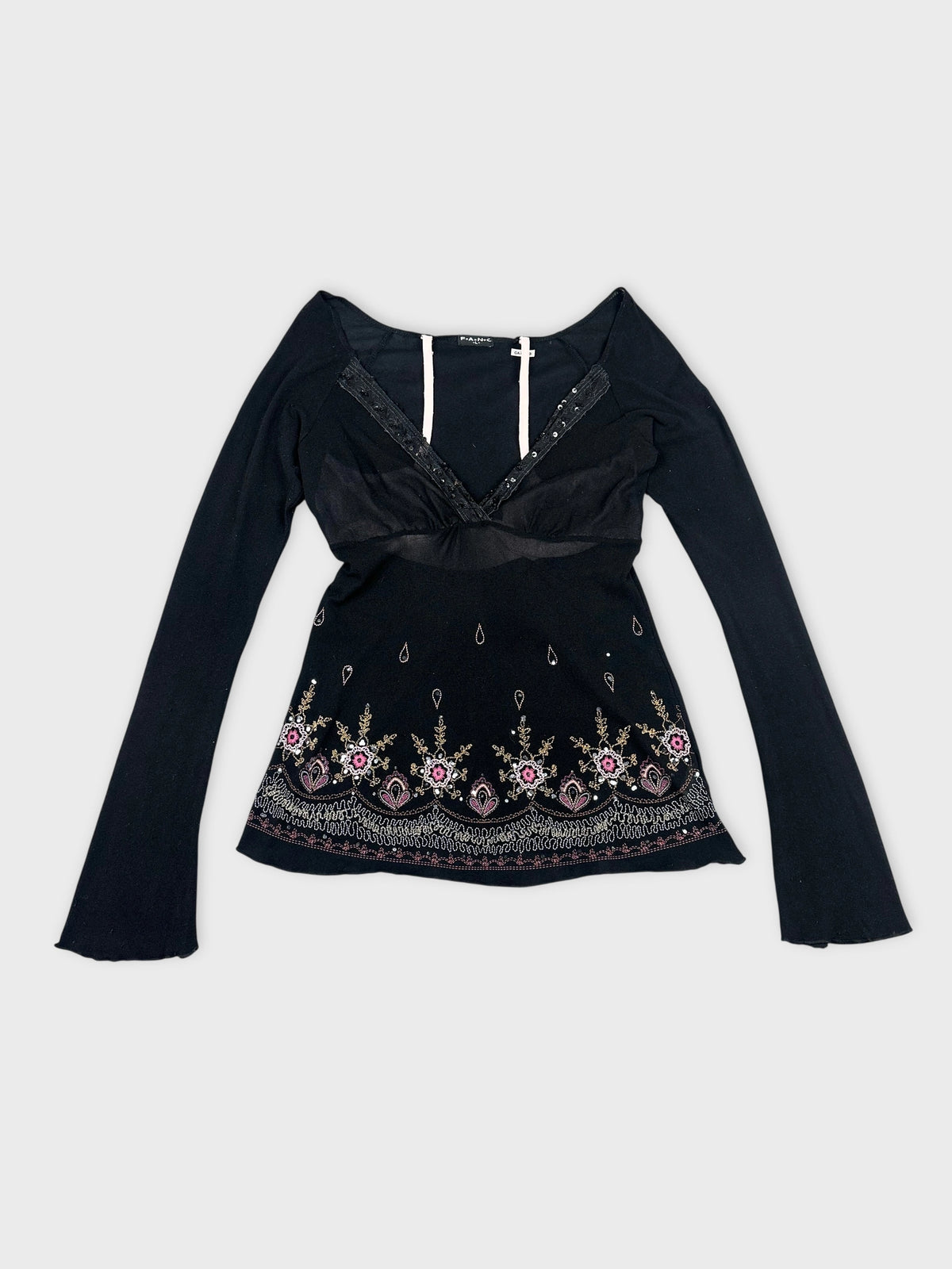 Front view of a black long sleeve top with floral embroidery