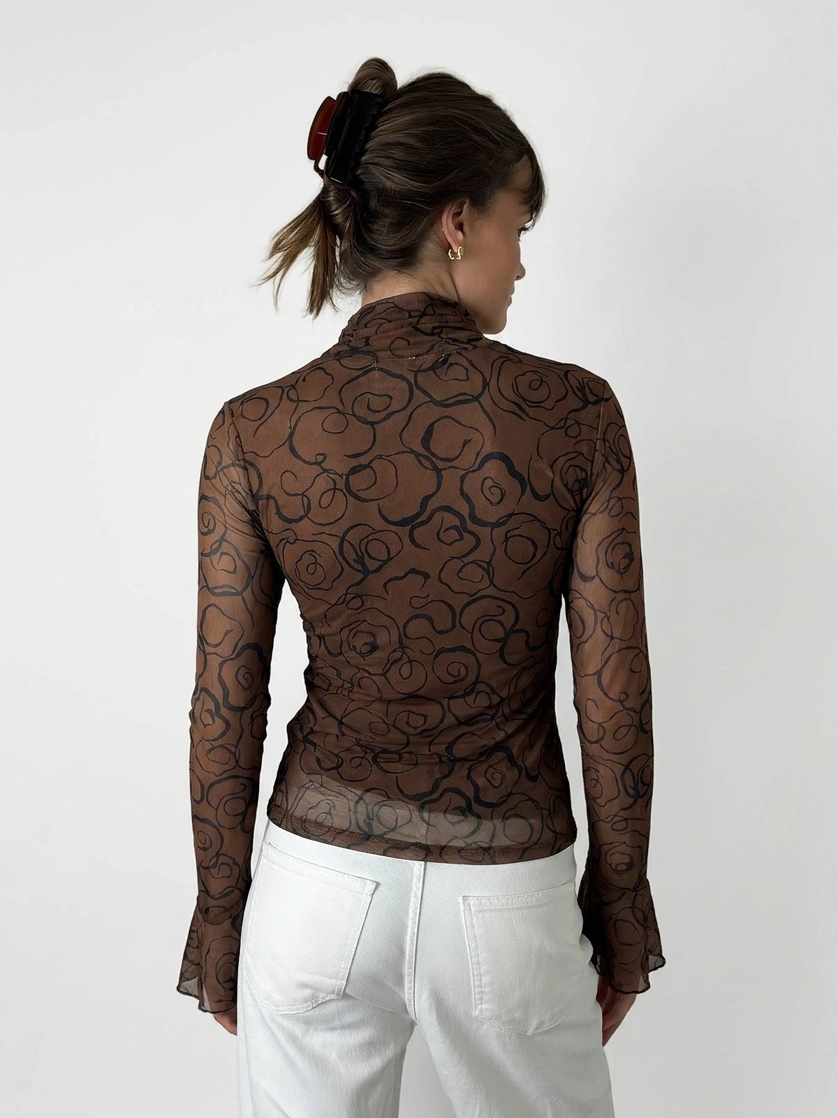 Back view of a long sleeve brown top with a floral pattern.