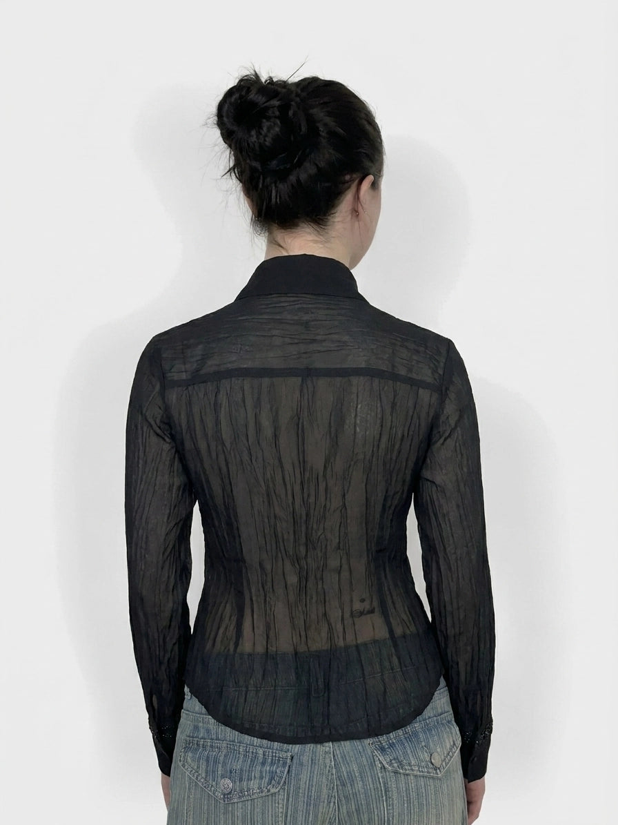 Back view of a black long sleeve top with a sheer textured design.