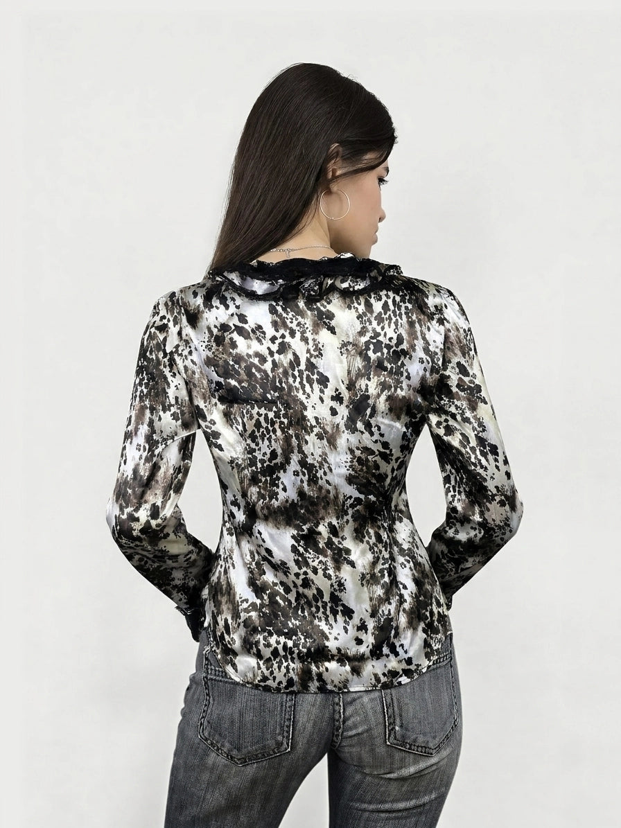 Back view of a long sleeve top in a black and white animal print with ruffled trim.
