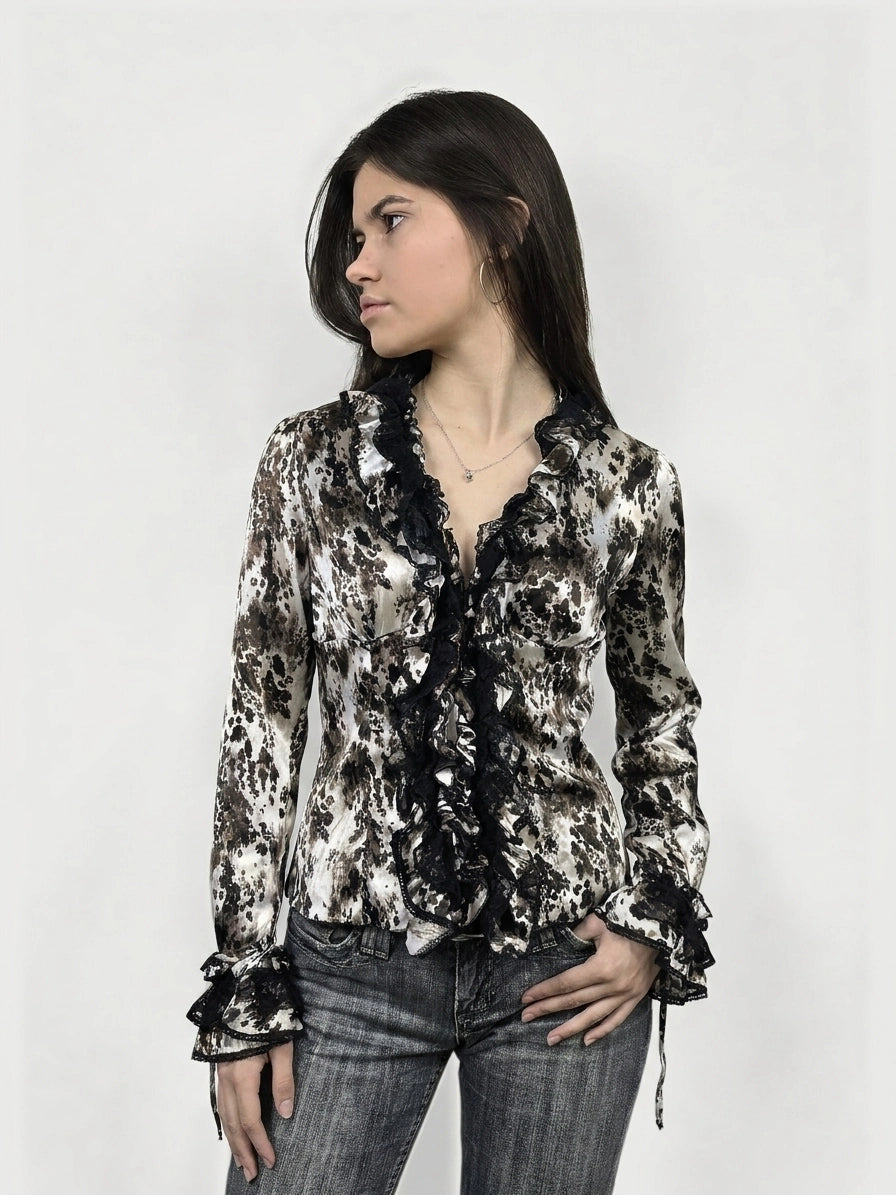 Long sleeve top in cream and brown with ruffled black trim, front view.