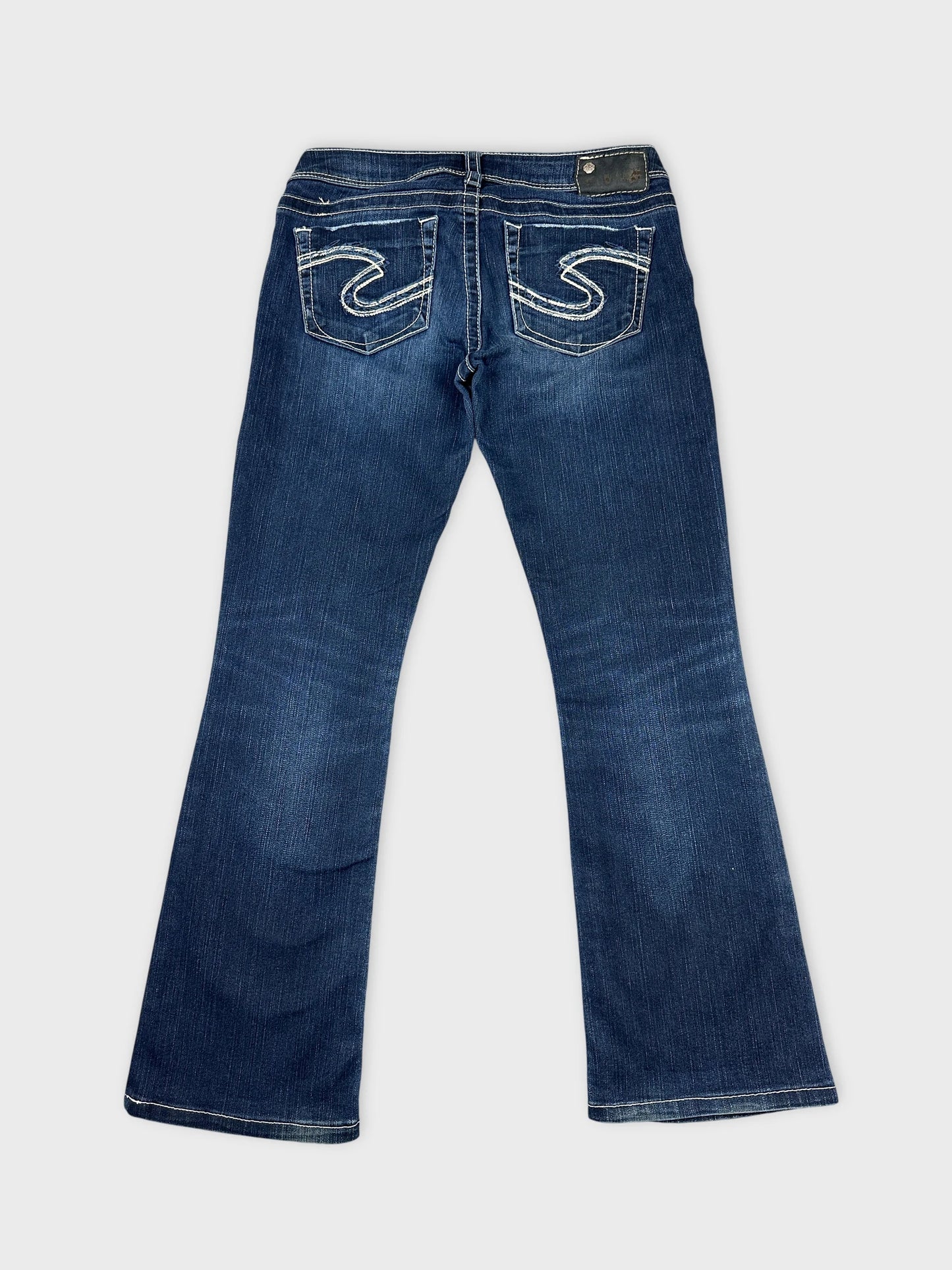 Back view of long wide jeans in dark blue with embroidered pockets.