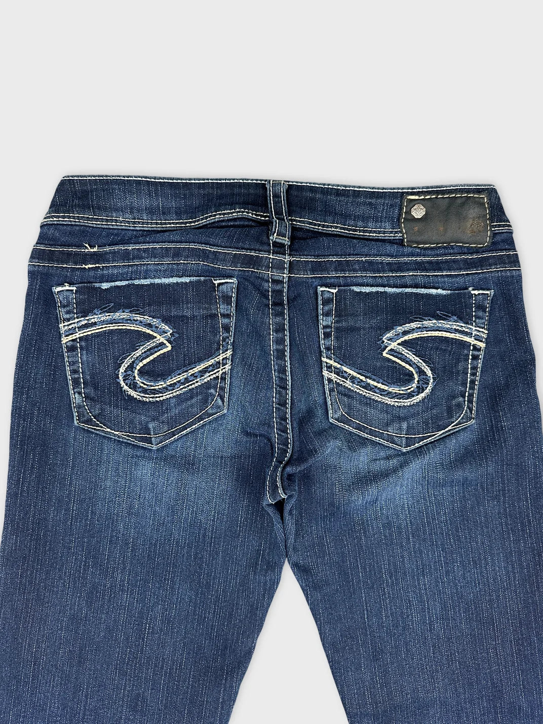 Detail view of women long wide jeans in dark blue with stylish back pockets